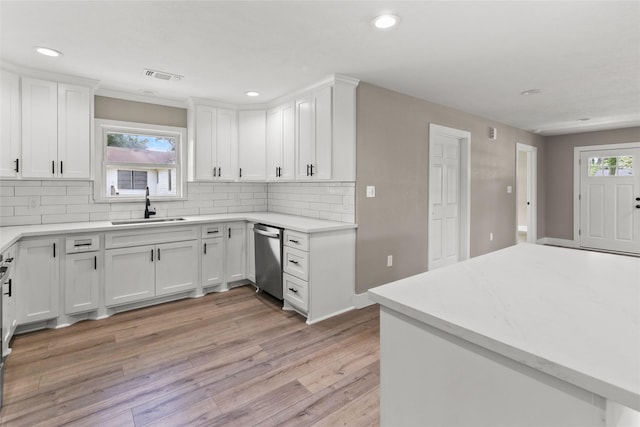318 Primrose Rd, Jones Creek, TX 77541 - kitchen featuring dishwasher, tasteful backsplash, light wood-style floors, light countertops, and white cabinets