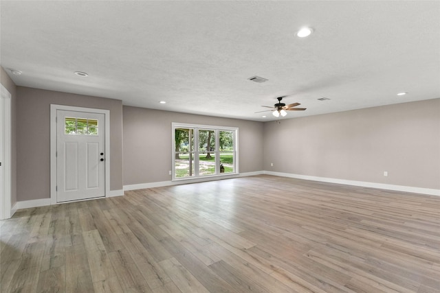 318 Primrose Rd, Jones Creek, TX 77541 - unfurnished living room with a ceiling fan, light wood-style floors, recessed lighting, and a textured ceiling
