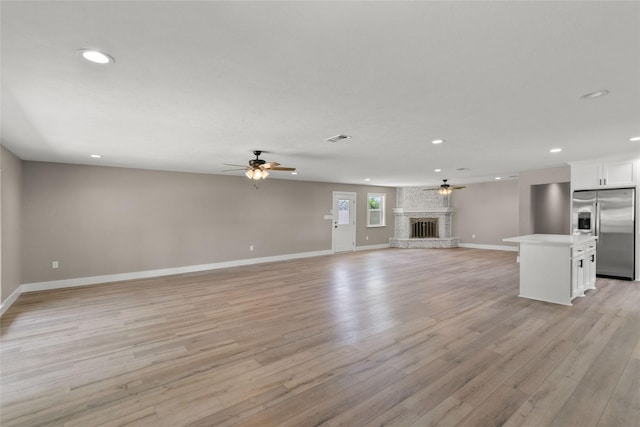 318 Primrose Rd, Jones Creek, TX 77541 - unfurnished living room with a ceiling fan, recessed lighting, light wood-type flooring, and a brick fireplace