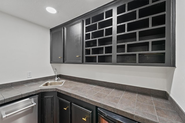 6711 Walton Heath Dr, Houston, TX 77069 - kitchen with stainless steel dishwasher, dark cabinetry, and dark countertops
