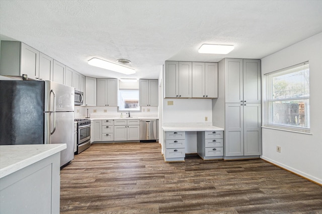 5730 Cartagena St, Houston, TX 77035 - kitchen with stainless steel appliances, gray cabinets, dark wood-type flooring, a textured ceiling, and light countertops