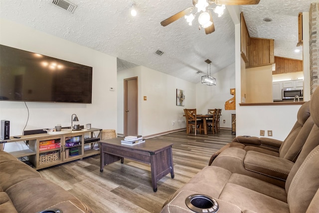 40 Crestbriar Ct, Baytown, TX 77521 - living area with ceiling fan, a textured ceiling, wood finished floors, and vaulted ceiling