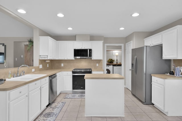 155 Fairwind Trail Dr, Conroe, TX 77385 - kitchen with appliances with stainless steel finishes, a center island, white cabinetry, decorative backsplash, and recessed lighting