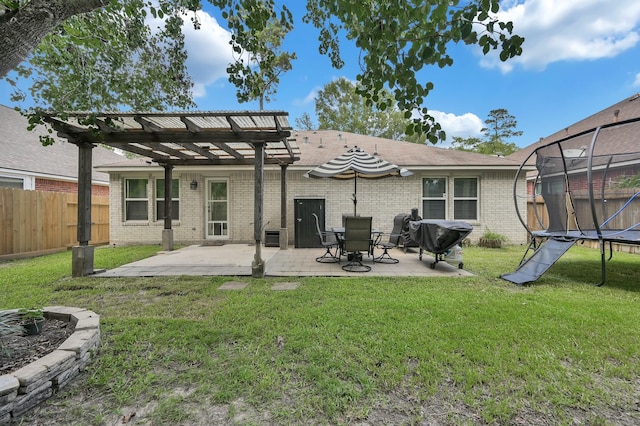 155 Fairwind Trail Dr, Conroe, TX 77385 - back of property featuring a pergola, a trampoline, brick siding, a patio area, and a fenced backyard