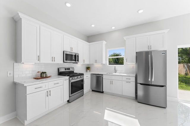 7407 Cora St, Houston, TX 77088 - kitchen with appliances with stainless steel finishes, light marble finish flooring, tasteful backsplash, white cabinetry, and recessed lighting