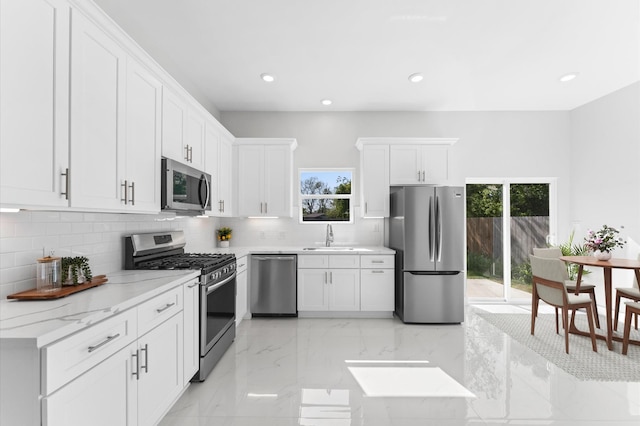 7407 Cora St, Houston, TX 77088 - kitchen with appliances with stainless steel finishes, tasteful backsplash, white cabinets, and recessed lighting