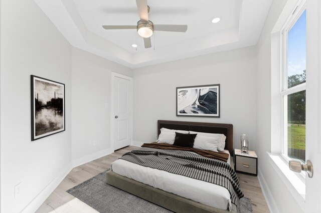 7407 Cora St, Houston, TX 77088 - bedroom featuring light wood-style flooring, a raised ceiling, recessed lighting, and ceiling fan