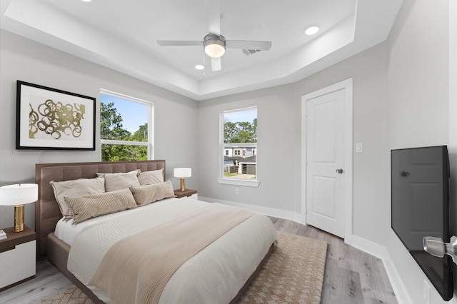 7407 Cora St, Houston, TX 77088 - bedroom with light wood-type flooring, a tray ceiling, recessed lighting, and a ceiling fan