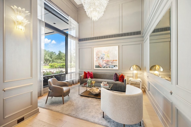 5100 San Felipe St Unit 353, Houston, TX 77056 - living area featuring a decorative wall, a chandelier, a high ceiling, and light wood-type flooring