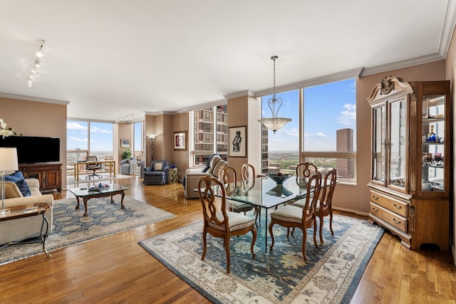 5100 San Felipe St Unit 353, Houston, TX 77056 - dining space with crown molding, plenty of natural light, rail lighting, light wood finished floors, and floor to ceiling windows