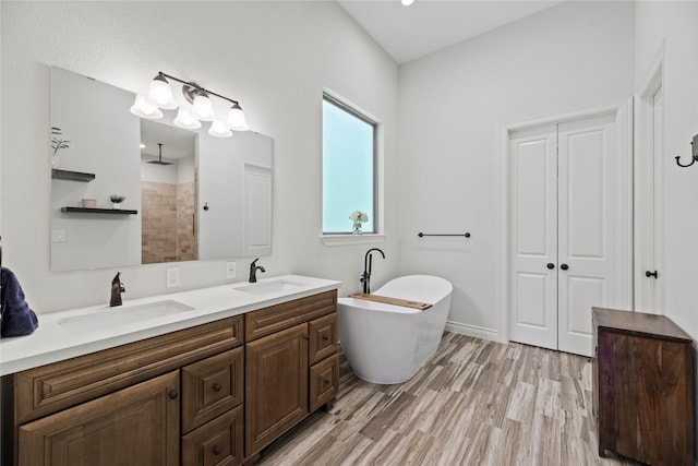 25010 Butler Hill Ct, Tomball, TX 77375 - bathroom featuring a freestanding bath, double vanity, tiled shower, and wood finished floors