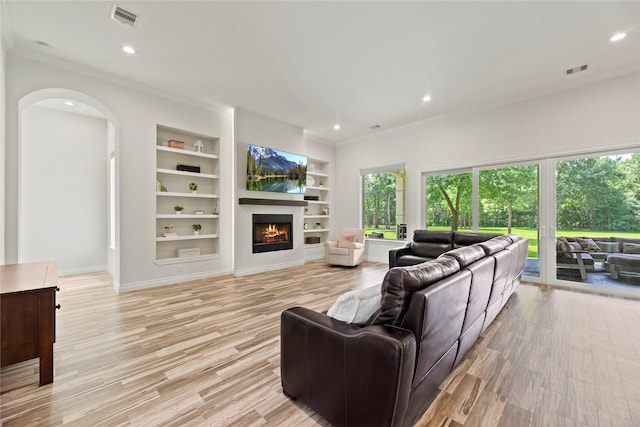 25010 Butler Hill Ct, Tomball, TX 77375 - living room with crown molding, built in features, a lit fireplace, light wood-type flooring, and recessed lighting