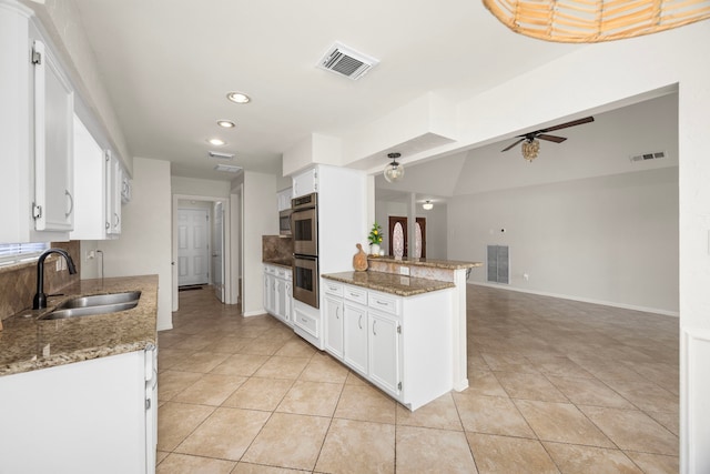 6114 Elkwood Forest Dr, Houston, TX 77088 - kitchen with double oven, ceiling fan, light tile patterned floors, white cabinets, and recessed lighting