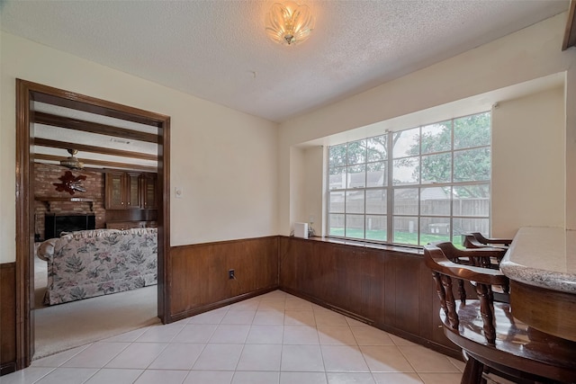 1015 Devonport Ln, Seabrook, TX 77586 - dining space featuring wainscoting, ceiling fan, a textured ceiling, wood walls, and light tile patterned floors