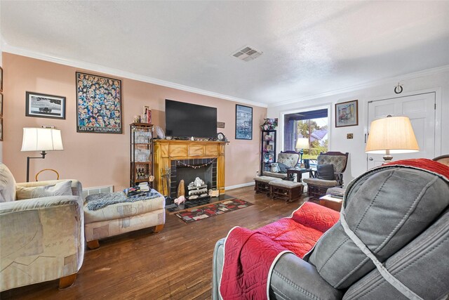 1012 Joyce St, Houston, TX 77009 - living area featuring ornamental molding, hardwood / wood-style flooring, and a tiled fireplace