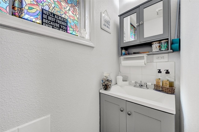 1012 Joyce St, Houston, TX 77009 - bathroom featuring decorative backsplash, vanity, and a textured wall