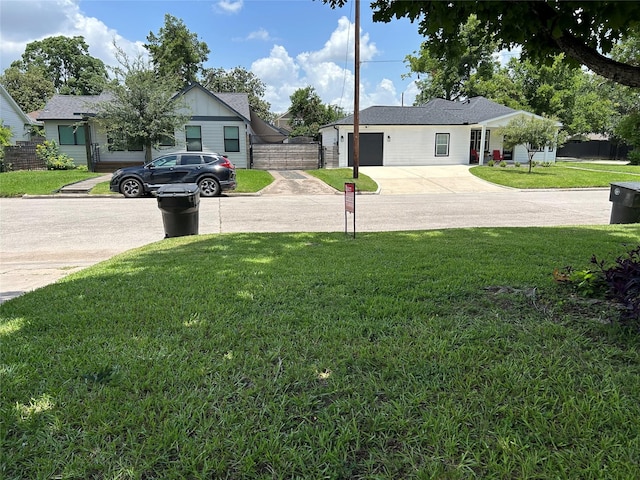 1012 Joyce St, Houston, TX 77009 - view of green lawn with concrete driveway and an attached garage