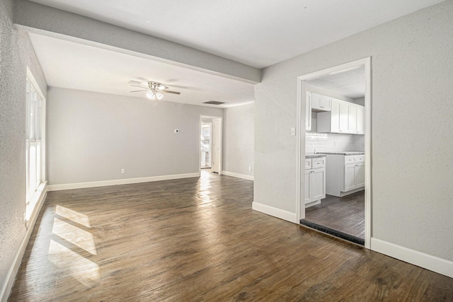 5715 Willow Glen Dr, Houston, TX 77033 - unfurnished living room featuring dark wood finished floors, ceiling fan, and a textured wall