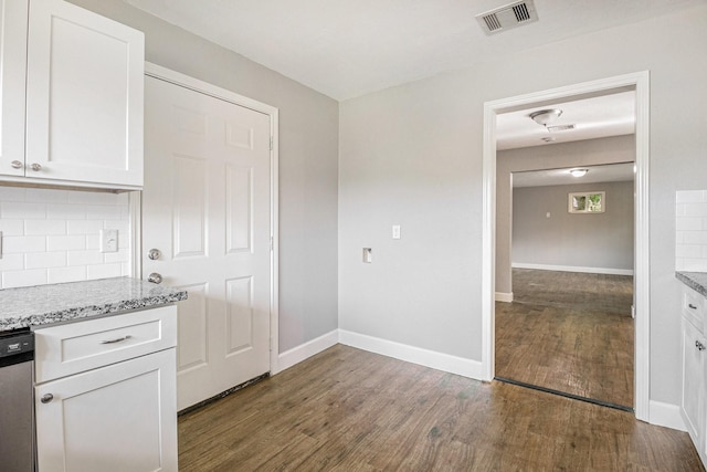 5715 Willow Glen Dr, Houston, TX 77033 - kitchen with dark wood-type flooring, white cabinets, backsplash, stainless steel dishwasher, and light stone counters