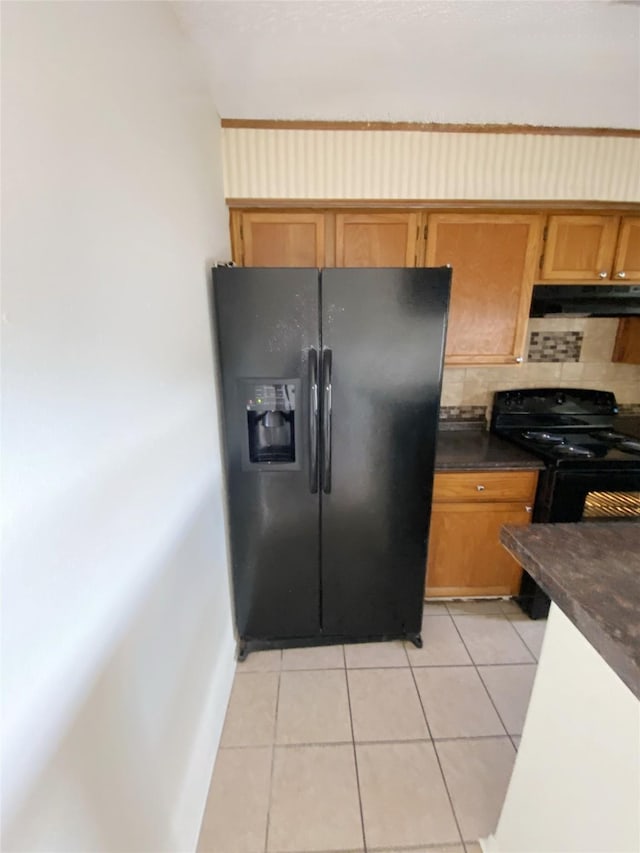 3100 Jeanetta St Unit 304, Houston, TX 77063 - kitchen with black appliances, under cabinet range hood, dark countertops, light tile patterned floors, and tasteful backsplash
