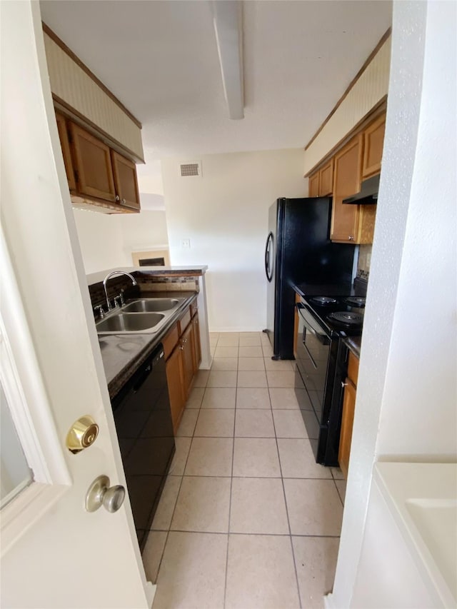 3100 Jeanetta St Unit 304, Houston, TX 77063 - kitchen with black appliances, under cabinet range hood, brown cabinetry, and light tile patterned floors