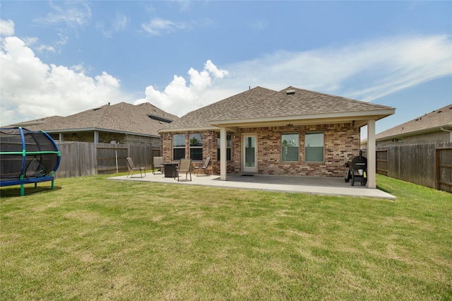 2426 Gentle Breeze Ln, Baytown, TX 77523 - back of property with a trampoline, brick siding, a patio, and a fenced backyard