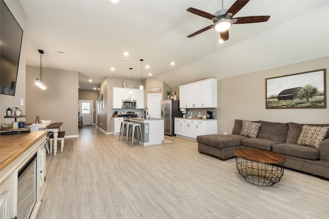 2426 Gentle Breeze Ln, Baytown, TX 77523 - living area with lofted ceiling, light wood-style floors, a ceiling fan, and recessed lighting