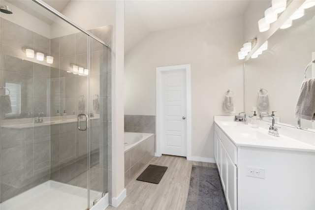 2426 Gentle Breeze Ln, Baytown, TX 77523 - full bathroom with wood finished floors, a bath, a stall shower, double vanity, and lofted ceiling