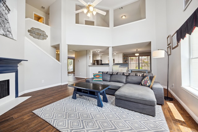 3282 Bend Cove Ct, League City, TX 77573 - living area with wood finished floors, ceiling fan, a fireplace with flush hearth, and a towering ceiling