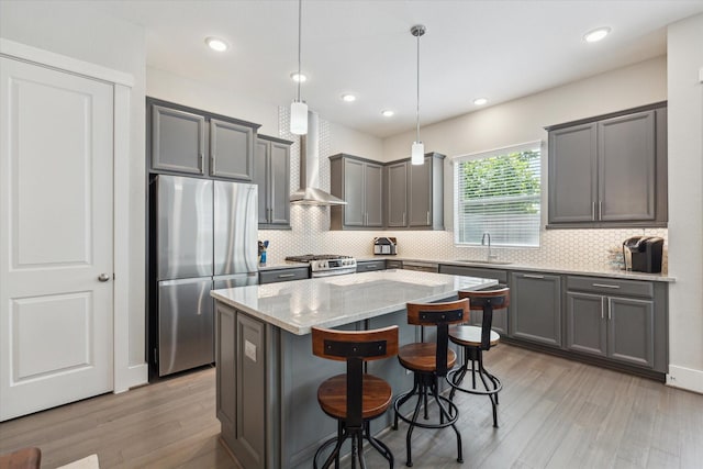1507 Biondo Way, Houston, TX 77008 - kitchen featuring stainless steel appliances, wall chimney exhaust hood, light stone counters, a center island, and a breakfast bar area