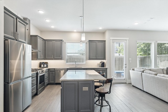 1507 Biondo Way, Houston, TX 77008 - kitchen with stainless steel appliances, a kitchen breakfast bar, light wood finished floors, backsplash, and recessed lighting