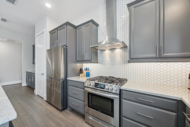 1507 Biondo Way, Houston, TX 77008 - kitchen featuring appliances with stainless steel finishes, wall chimney exhaust hood, gray cabinets, wood finished floors, and decorative backsplash