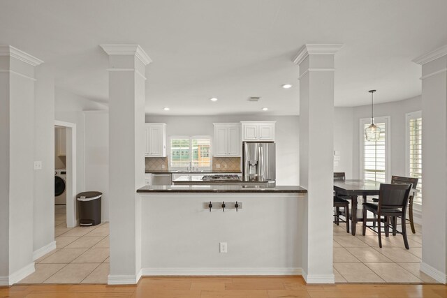 14210 Northface Manor Ct, Cypress, TX 77429 - kitchen featuring stainless steel appliances, ornate columns, dark countertops, backsplash, and white cabinets