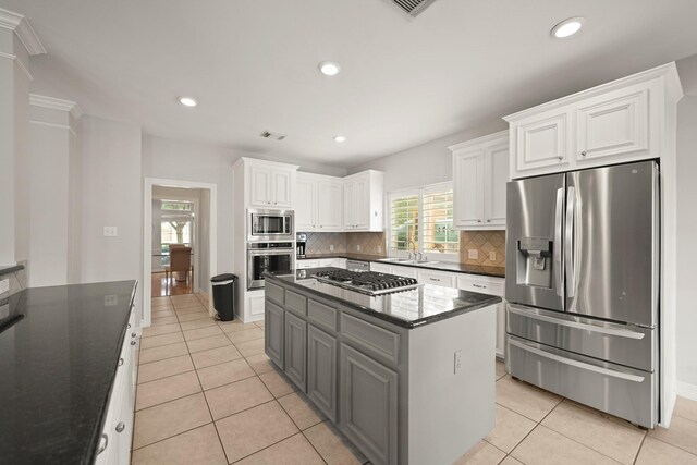14210 Northface Manor Ct, Cypress, TX 77429 - kitchen featuring appliances with stainless steel finishes, white cabinets, light tile patterned flooring, decorative backsplash, and recessed lighting
