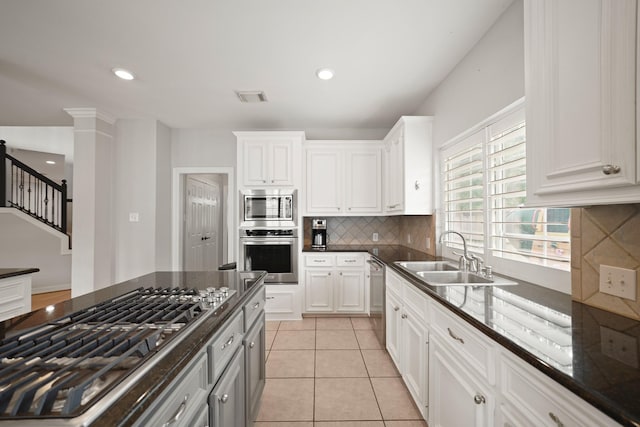 14210 Northface Manor Ct, Cypress, TX 77429 - kitchen with stainless steel appliances, backsplash, white cabinets, dark stone countertops, and light tile patterned flooring