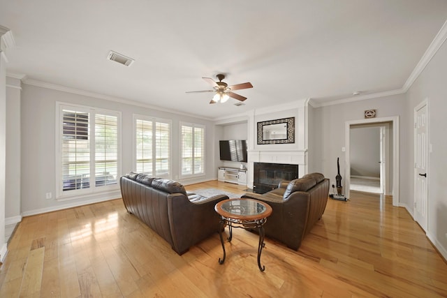 14210 Northface Manor Ct, Cypress, TX 77429 - living room featuring ornamental molding, a glass covered fireplace, ceiling fan, and light wood finished floors
