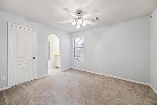 831 W 26th St, Houston, TX 77008 - unfurnished bedroom with arched walkways, carpet floors, ensuite bathroom, and a ceiling fan