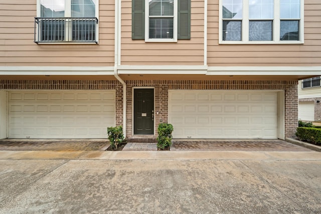 3001 Murworth Dr Unit 1606, Houston, TX 77025 - doorway to property featuring an attached garage, concrete driveway, and brick siding