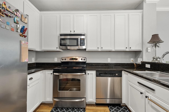 3001 Murworth Dr Unit 1606, Houston, TX 77025 - kitchen featuring stainless steel appliances, white cabinets, light wood finished floors, and ornamental molding