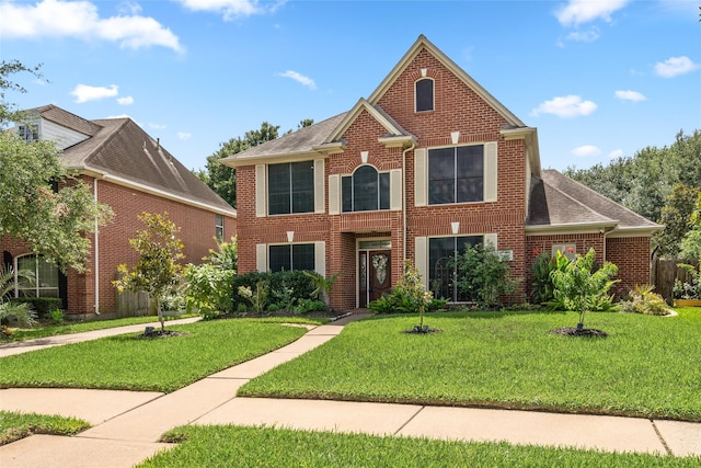 7943 Scenic Canyon Ln, Houston, TX 77095 - colonial house featuring a front lawn, brick siding, and roof with shingles