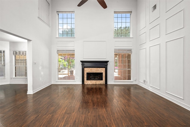 7943 Scenic Canyon Ln, Houston, TX 77095 - unfurnished living room with a towering ceiling, a ceiling fan, a stone fireplace, and dark wood finished floors