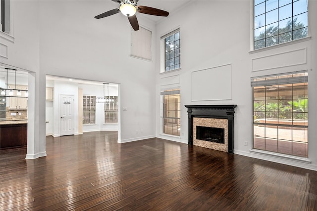 7943 Scenic Canyon Ln, Houston, TX 77095 - unfurnished living room featuring ceiling fan, a towering ceiling, a fireplace, and dark wood-type flooring