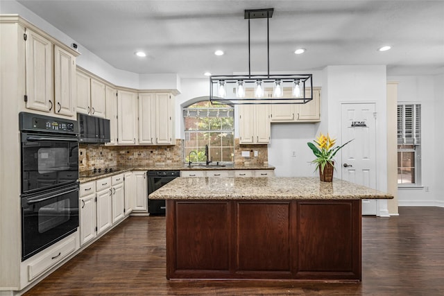 7943 Scenic Canyon Ln, Houston, TX 77095 - kitchen with black appliances, dark wood-style floors, light stone countertops, backsplash, and a kitchen island