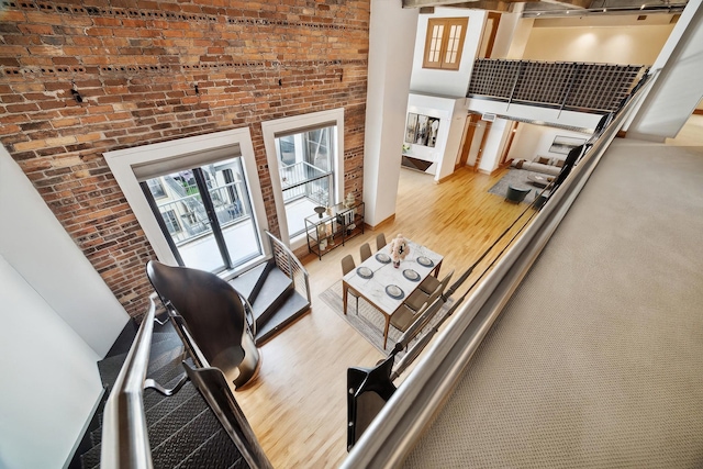 915 Franklin St Unit 9L, Houston, TX 77002 - living area with wood finished floors, a high ceiling, and brick wall