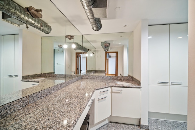 915 Franklin St Unit 9L, Houston, TX 77002 - kitchen with white cabinets, dark stone counters, and decorative light fixtures
