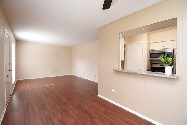 9007 Gaylord St Unit 23, Houston, TX 77024 - unfurnished living room featuring dark wood-type flooring, ceiling fan, and a textured ceiling