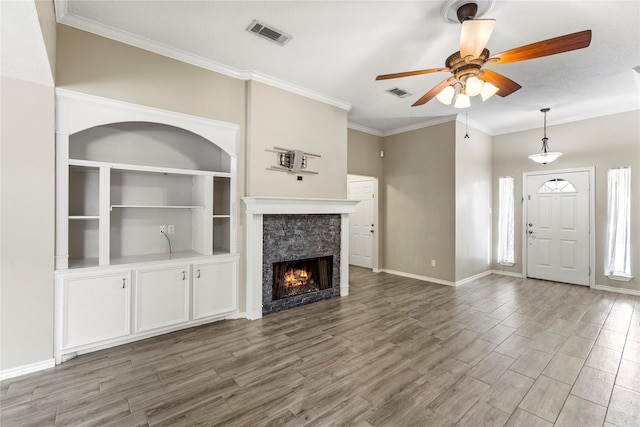 110 Rustling Wind Dr, Montgomery, TX 77356 - unfurnished living room with ceiling fan, wood finished floors, a stone fireplace, and crown molding