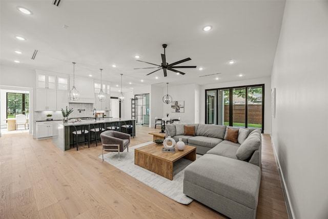431 W 30th St, Houston, TX 77018 - living room featuring recessed lighting, plenty of natural light, light wood-type flooring, a ceiling fan, and a chandelier