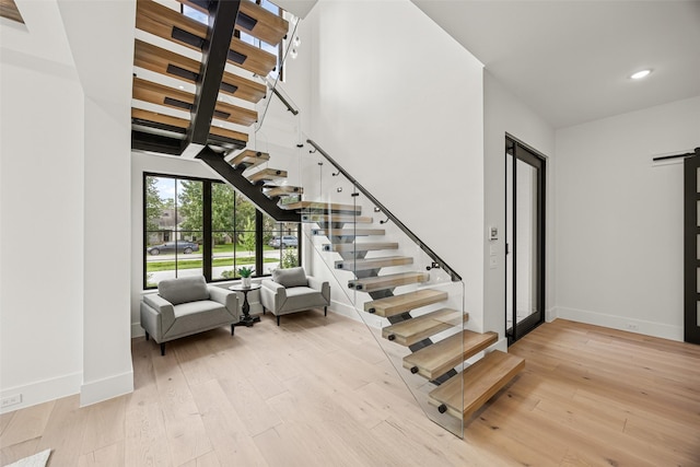 431 W 30th St, Houston, TX 77018 - staircase featuring a barn door, hardwood / wood-style floors, recessed lighting, and a towering ceiling