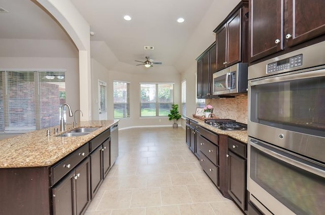 4327 Estes Ridge Ln, Katy, TX 77493 - kitchen with appliances with stainless steel finishes, tasteful backsplash, ceiling fan, light stone counters, and dark brown cabinetry